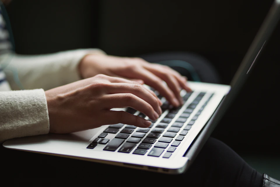 Persona che usa il portatile digitando sulla tastiera